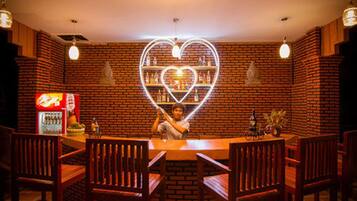 A restaurant with a brick wall and a neon heart-shaped light fixture.
