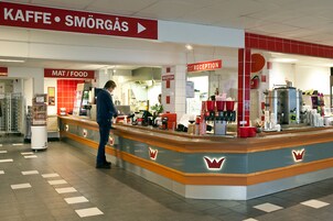 Zona de recepción con mostrador, señalización de 'MAT/FOOD' y un letrero que dice 'RECEPTION'.