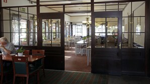 A restaurant with wooden furniture and large windows. - Rasta Hallandsåsen (Ostra Karup)