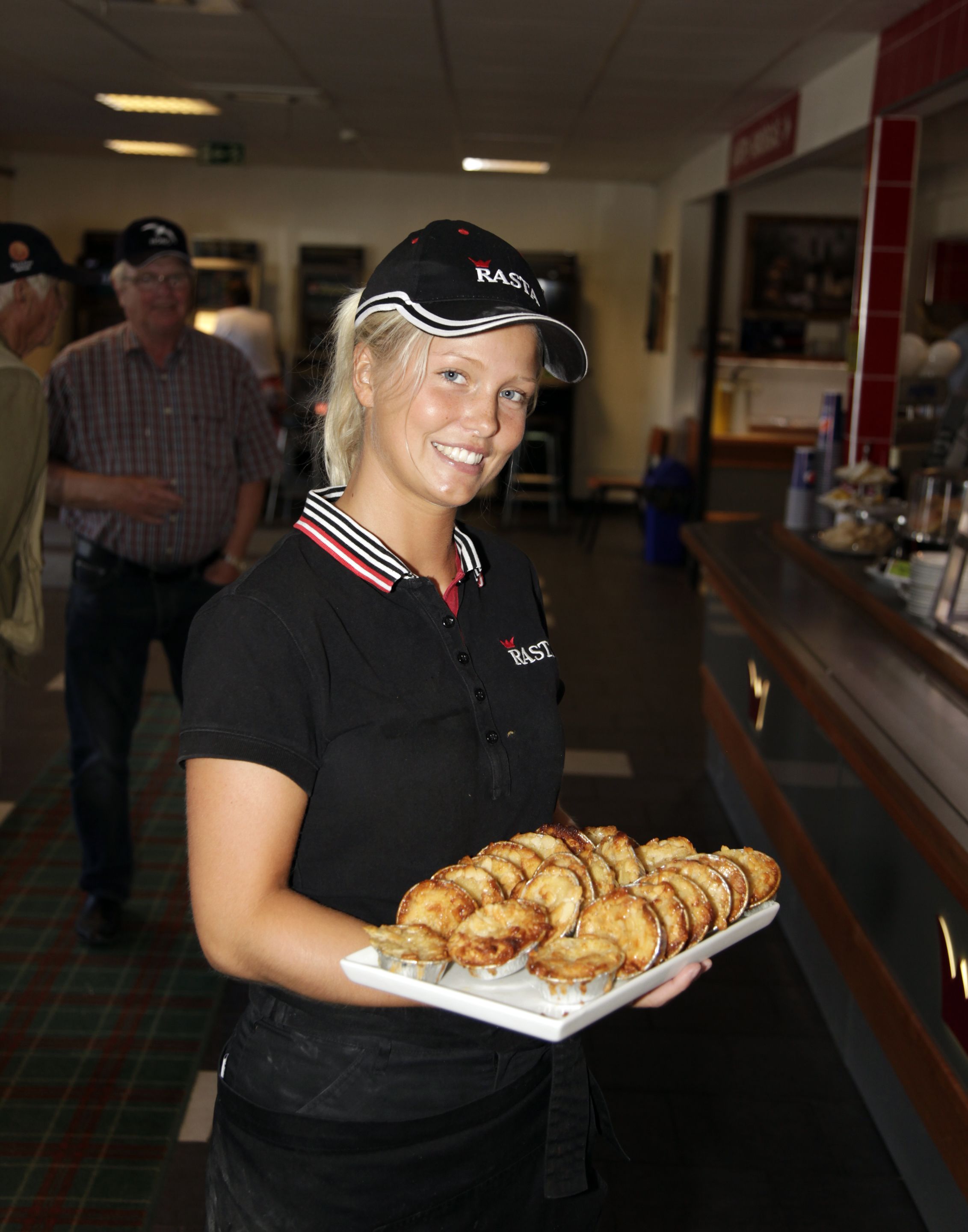 A person holding a plate of food in a commercial setting.