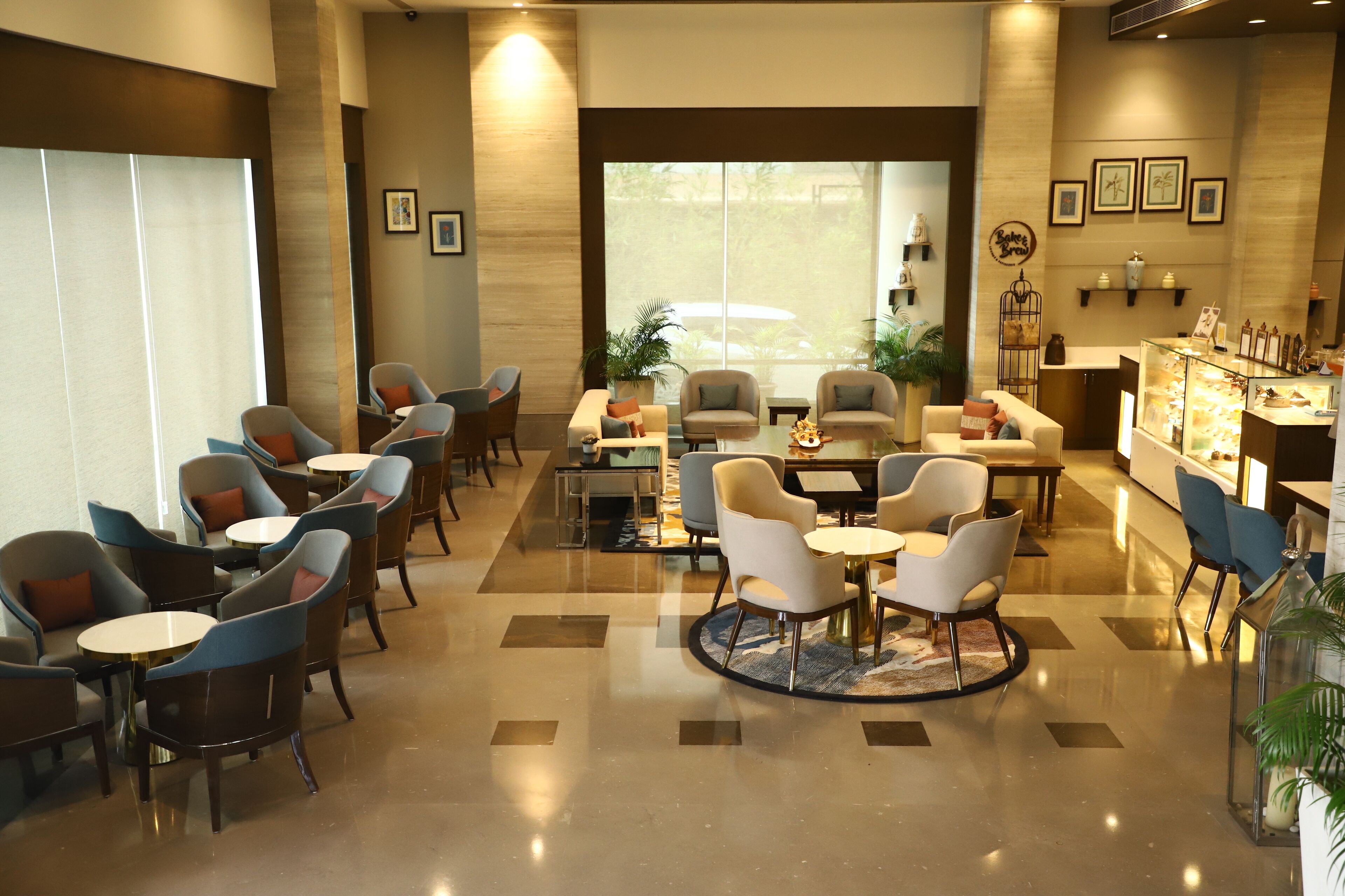 A spacious lobby with multiple seating areas, a reception desk, and a view of the outdoors.