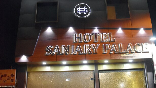Entrada de un hotel con un cartel que dice 'HOTEL SANJARY PALACE' y un logotipo sobre la entrada.