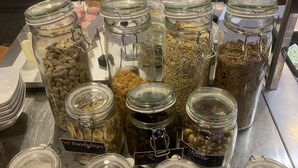 A buffet area with various food items in glass jars labeled with names like "Band Hip's," "Raspberry," and "Lemon."