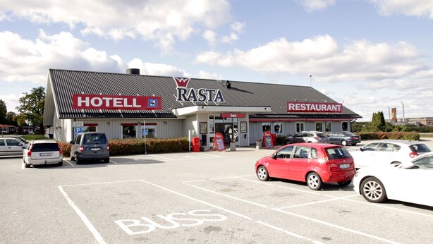 Un hotel y restaurante llamado Rasta con un estacionamiento.