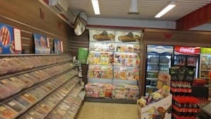 Interior de un supermercado con una barra de deli, mostrador refrigerado y un refrigerador de Coca-Cola.