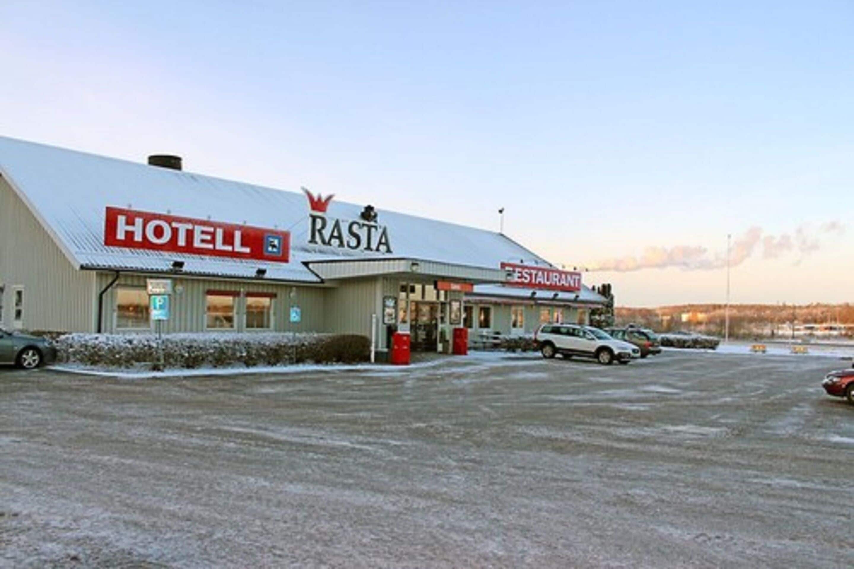 A hotel named Rasta with a restaurant and a parking lot.