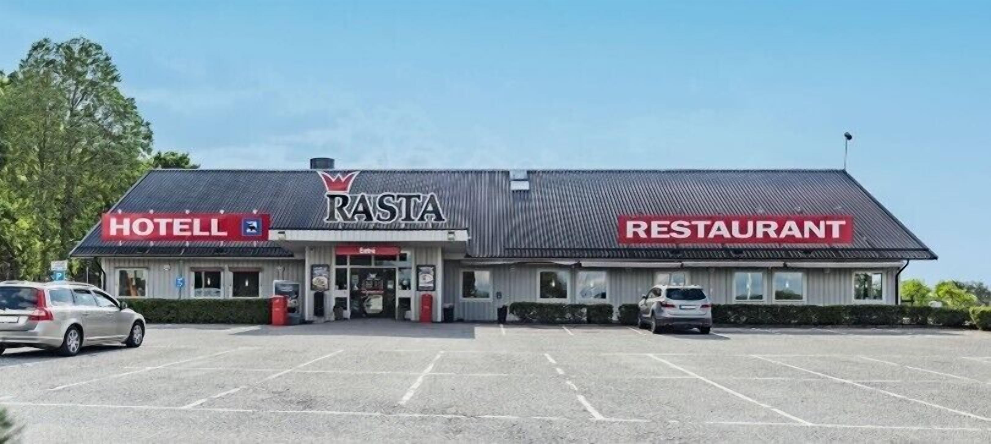 Ett hotell och en restaurang i rastastil med en parkeringsplats framför.