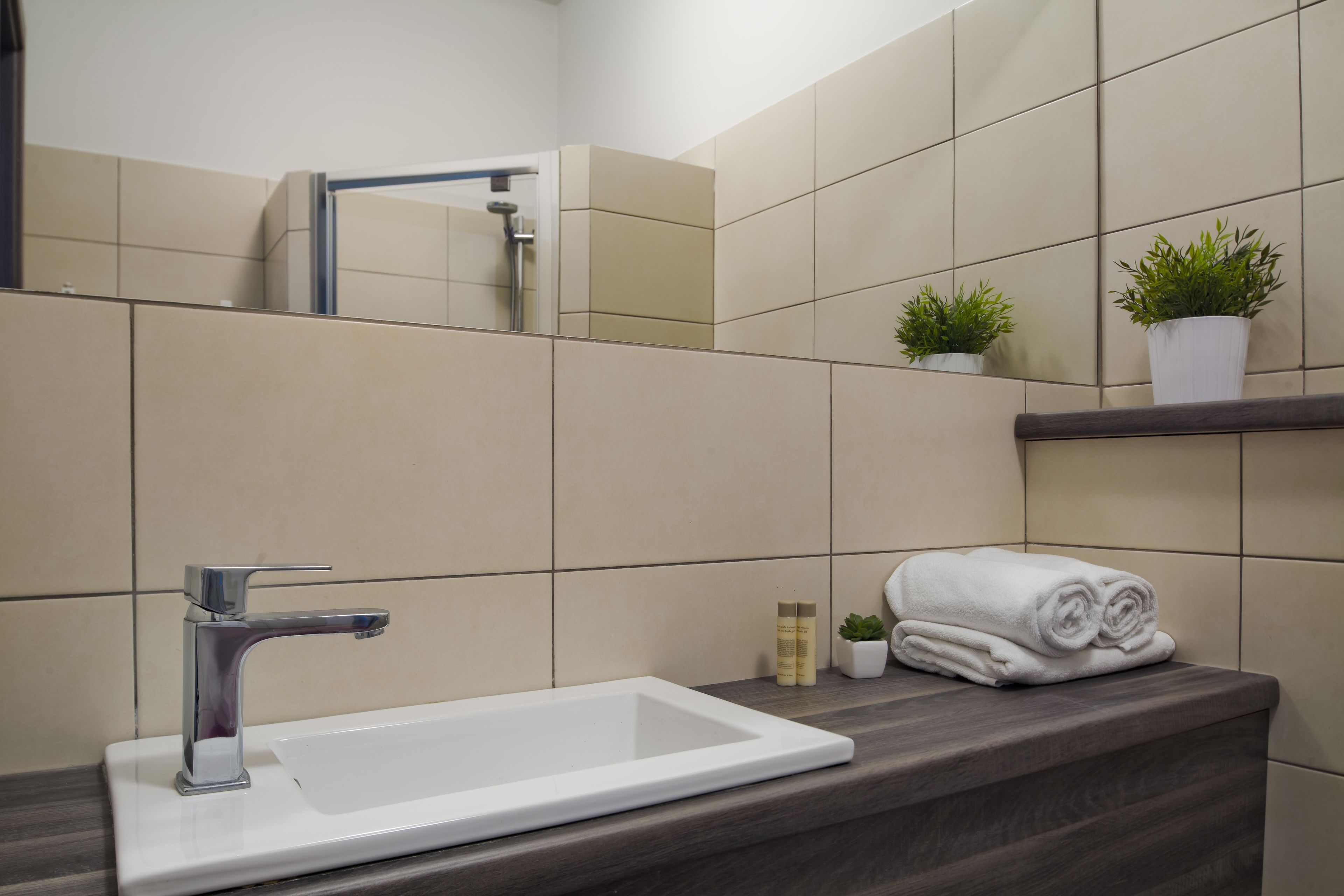 Une salle de bain avec un lavabo blanc, un miroir et une serviette posée sur le comptoir.