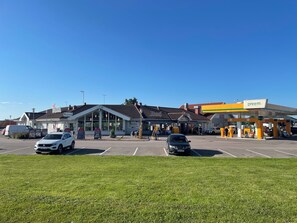 A parking lot with a restaurant named RASTA and a gas station.