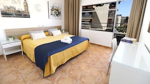 A hotel room with a bed, a desk, a window with a view of buildings, and a painting of a cityscape. - HSR Gil  (Calvia)