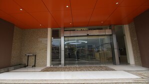 A modern building entrance with a glass door, a ramp, and a metal railing. - Pearlwort Hotel and Suites (Lagos)