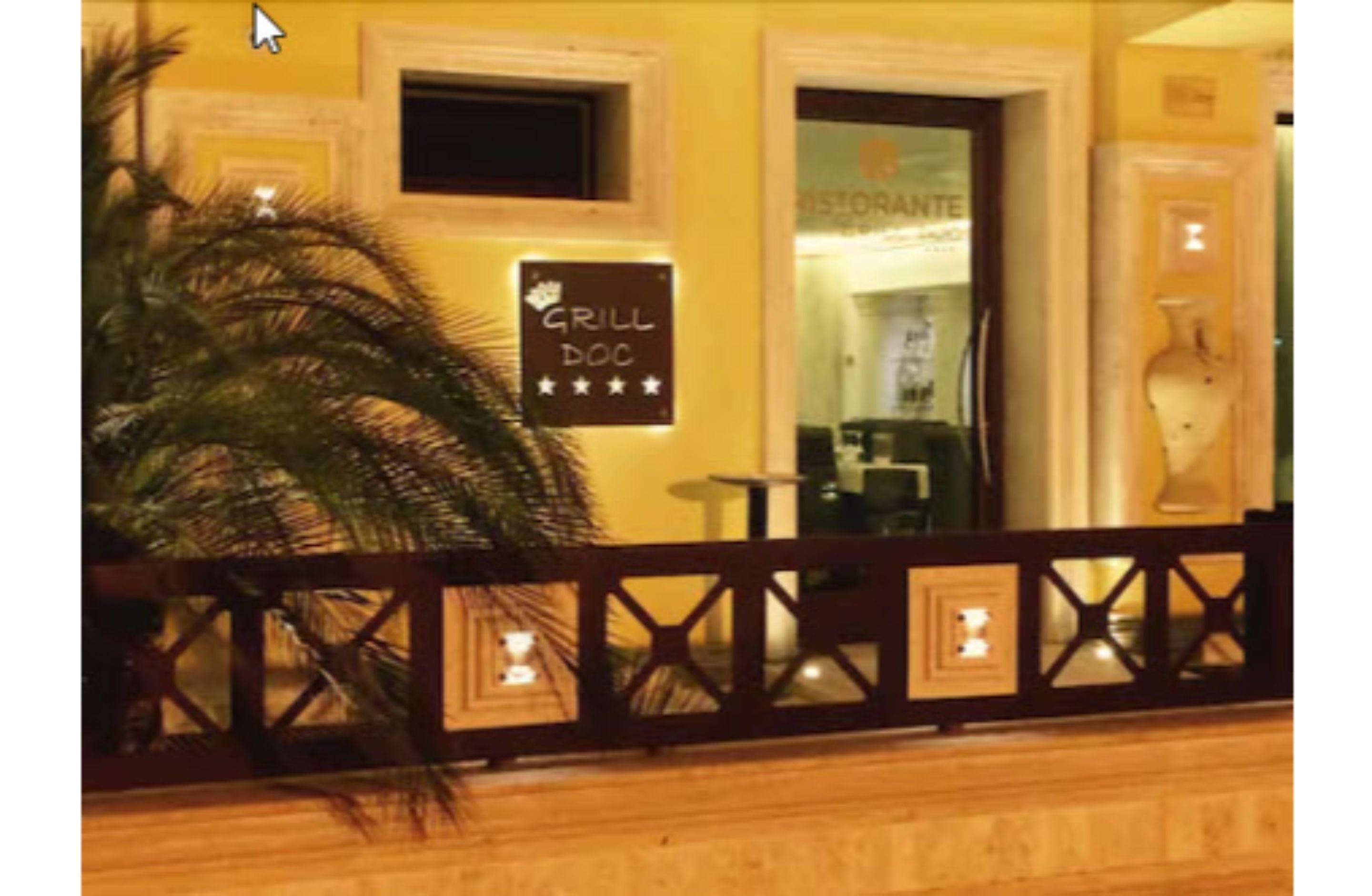 A restaurant with a sign reading "GRILL DOC" and a palm tree in the foreground.