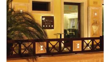 A restaurant with a sign reading "GRILL DOC" and a palm tree in the foreground.