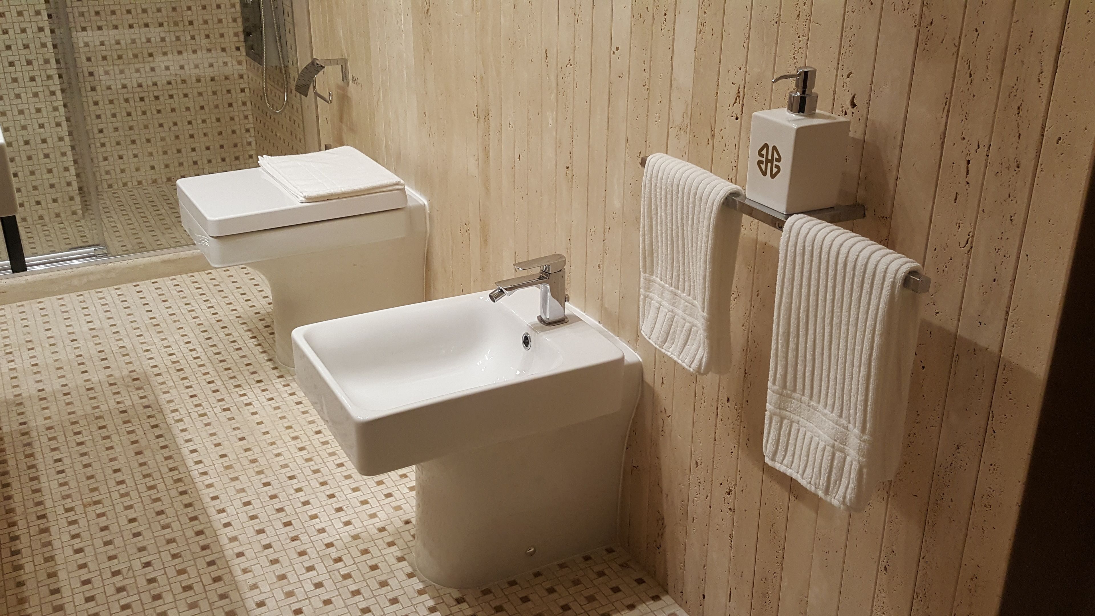 Un baño con lavamanos blanco, inodoro y zona de ducha.