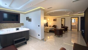 A spacious living area with a large flat-screen TV, a hot tub, and a seating area with leather chairs. - BHB Hotel (Manduria)