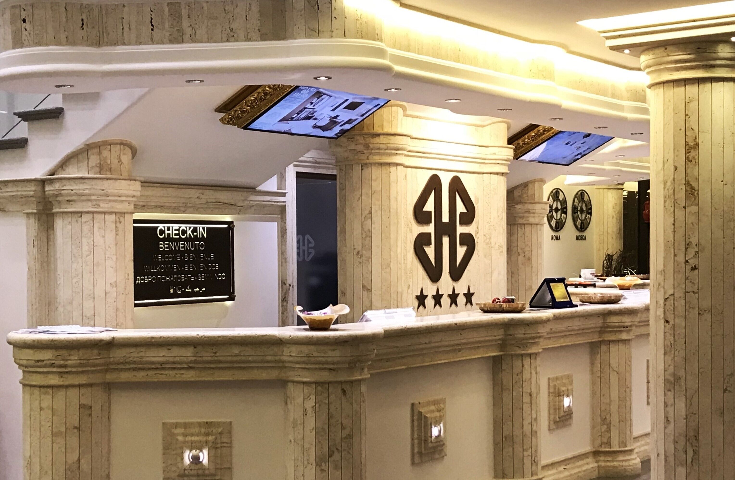 Una reception con la segnaletica per il check-in, un display digitale e un elemento decorativo.