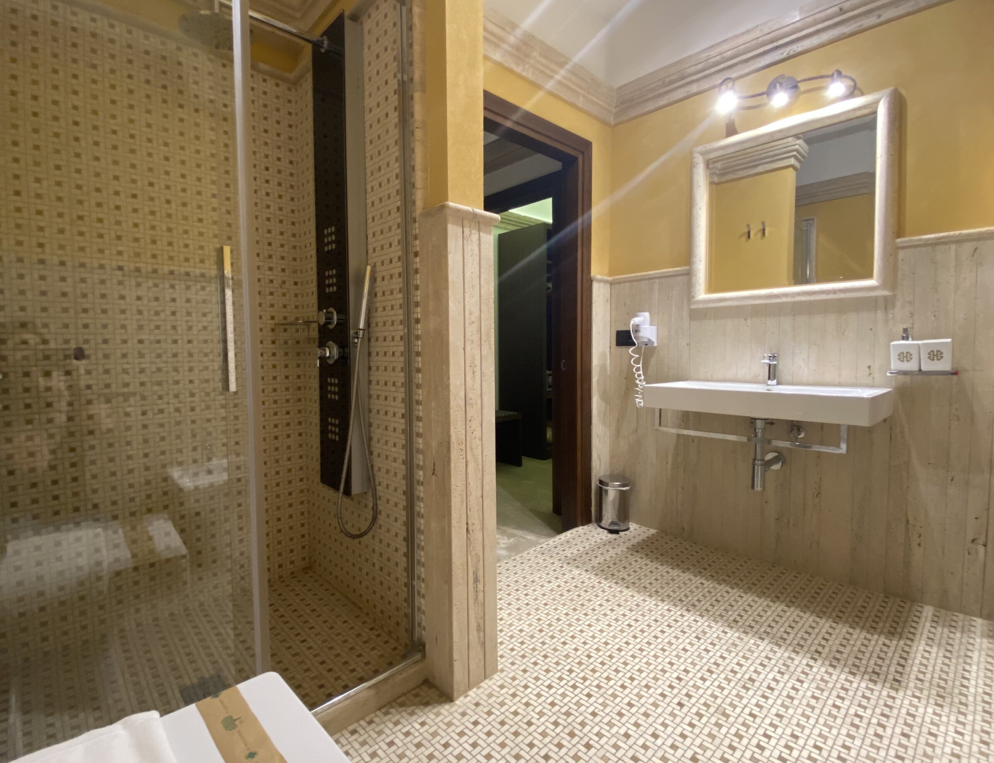 A bathroom with a shower, sink, and mirror.
