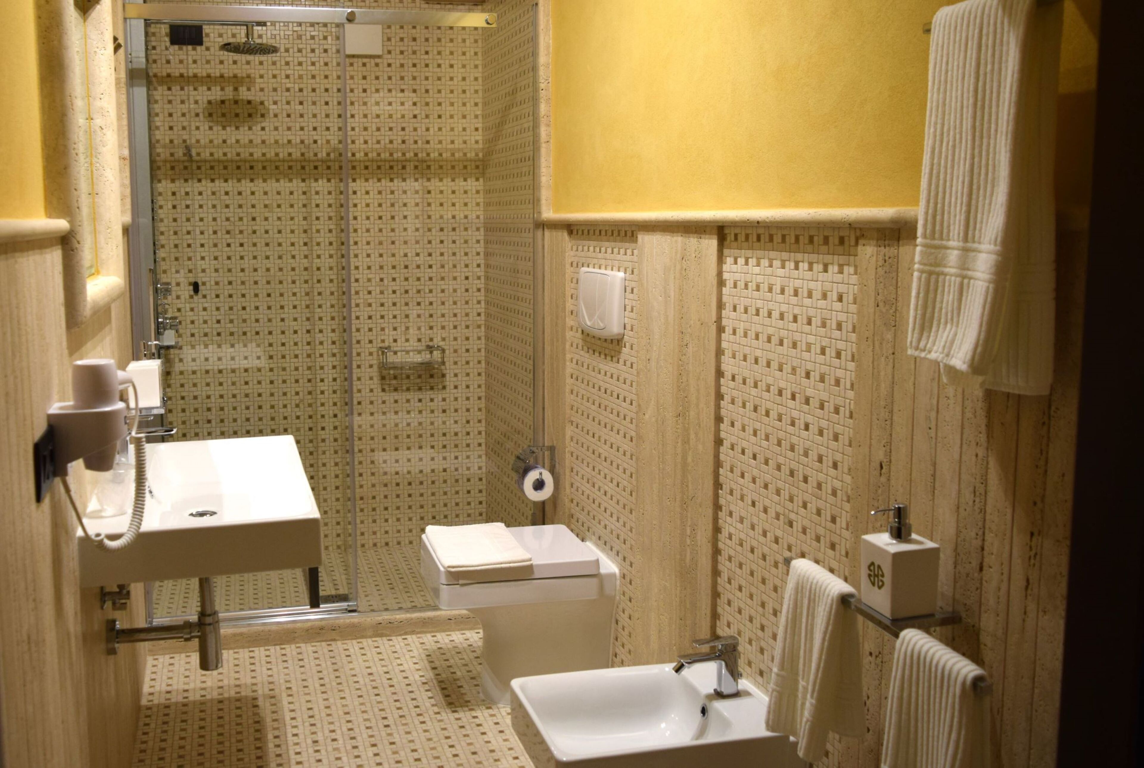 Une salle de bain comprenant un lavabo, des toilettes et un espace douche.