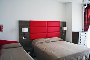 A hotel room with a red headboard, two beds, bedside lamps, a dresser, and a chandelier. - Hotel Buratti (Cervia)