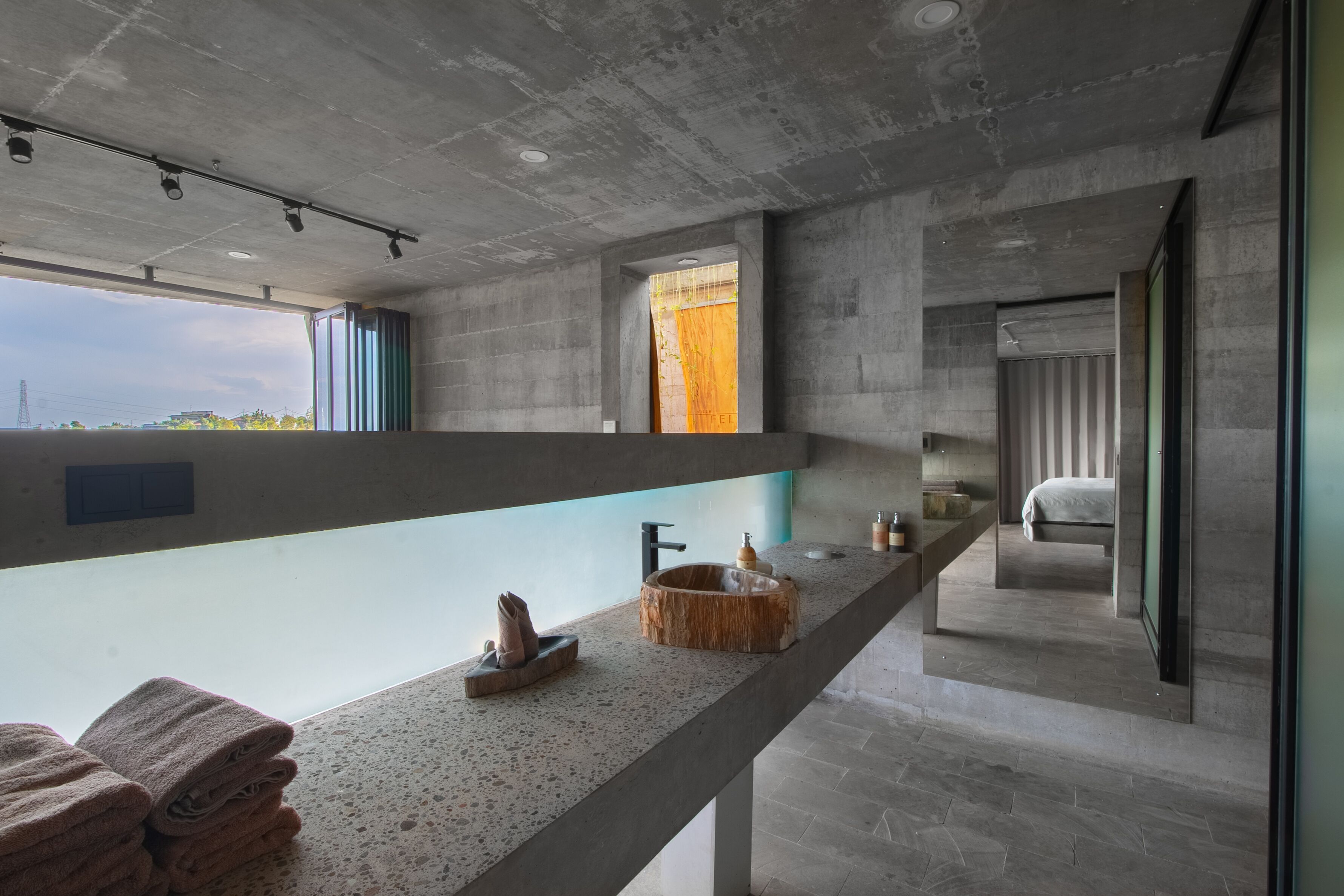 A modern bathroom with a long countertop, a sink, and a mirror.