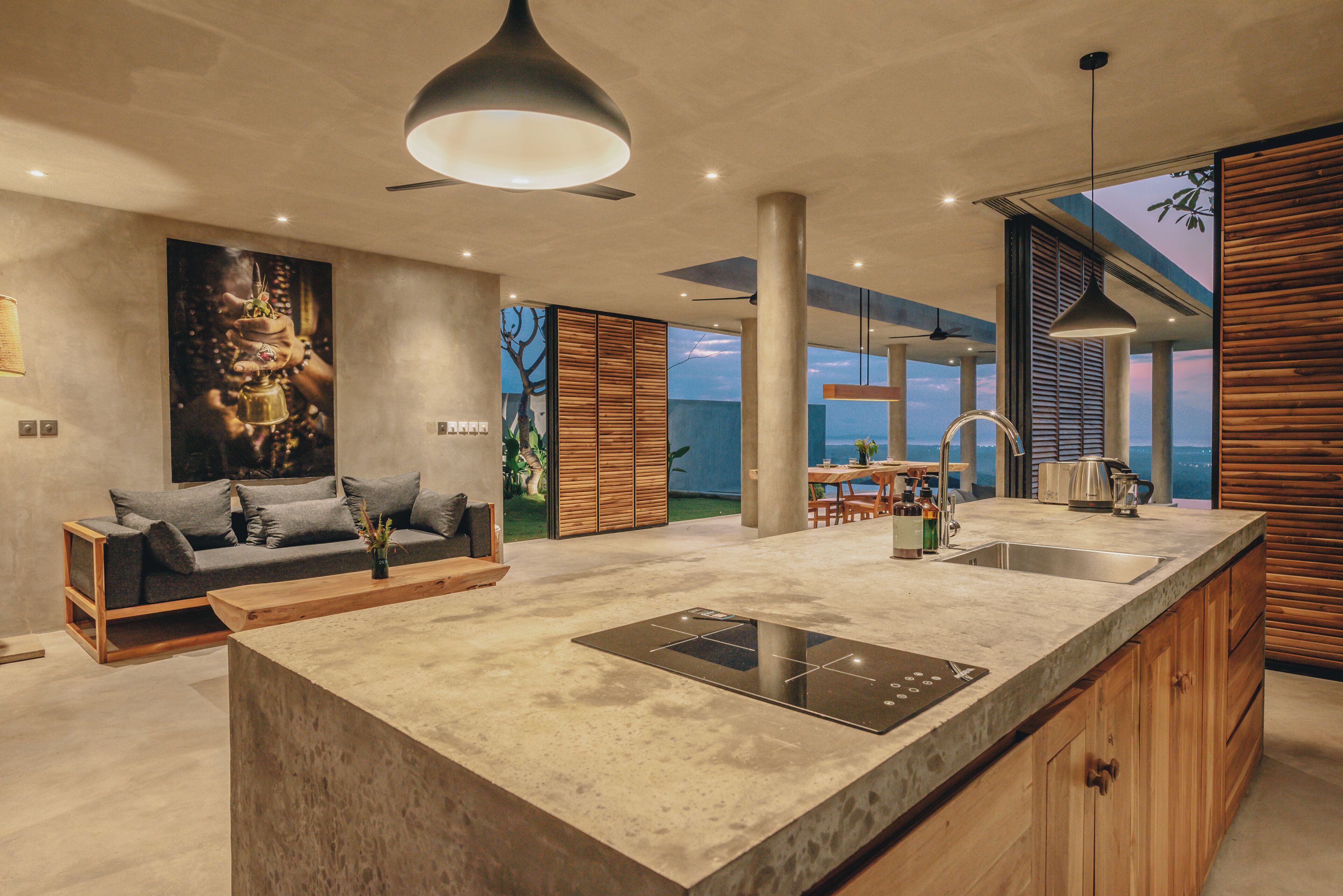 A modern kitchen with a large island, built-in appliances, and a dining area with a view.