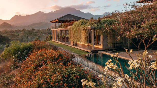 A modern house with a pool, surrounded by lush vegetation and mountains in the background. - Sumberkima Hill Private Villa Retreat (Pemuteran)