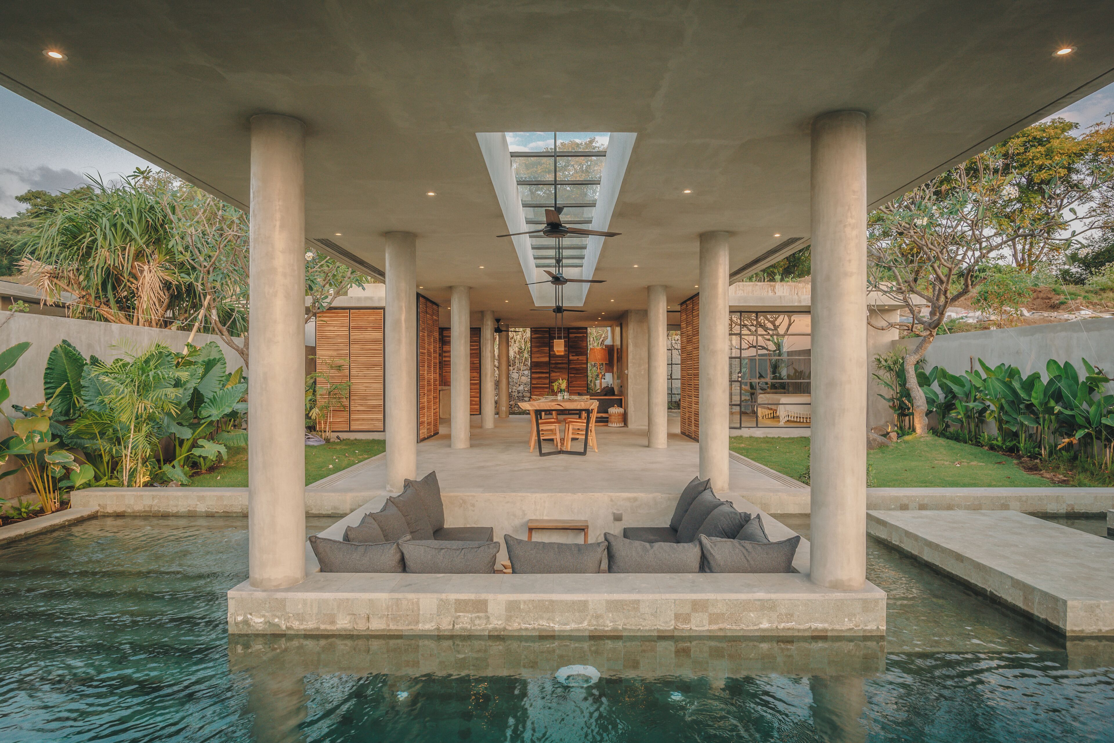 A modern outdoor pool area with a seating arrangement and a view of the interior.
