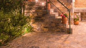 A stone staircase with terracotta pots and pink flowers. - Maria Plomari Apartments (Lesvos)