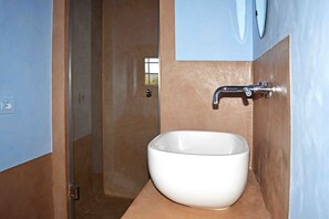 A bathroom with a white sink, a mirror, and a shower door. - Le Moraiole Country House (Massa Marittima)