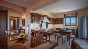 Una cocina amplia con armarios de madera, una isla central y un refrigerador de acero inoxidable.