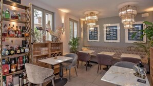 A cozy restaurant interior with a bar area, cushioned seating, and framed artwork on the walls. - Heritage Hotel 19 (Split)