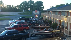Un motel doté d’un parking rempli de véhicules, notamment des voitures et des bateaux.