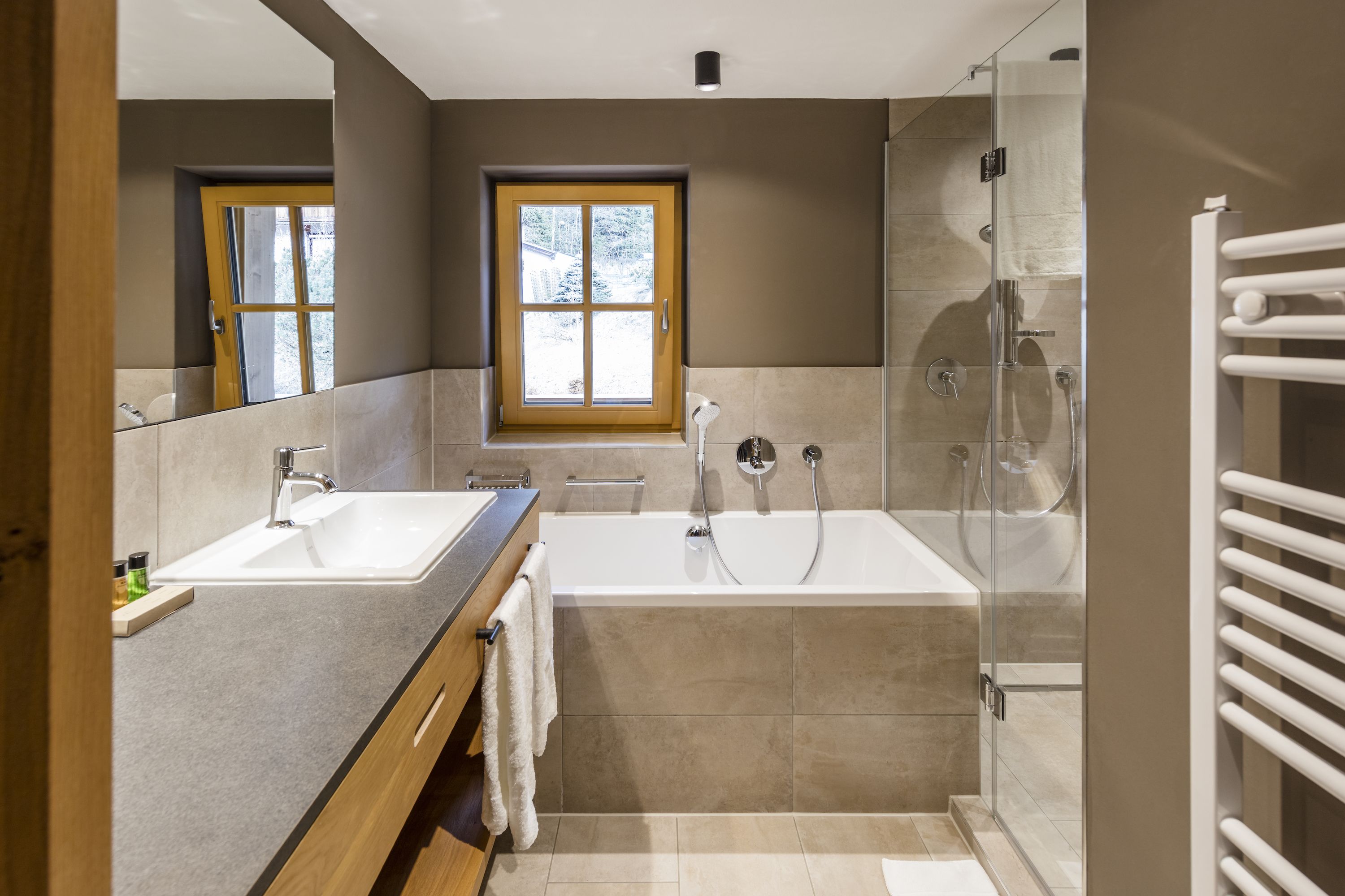 A modern bathroom with a large bathtub, a separate shower area, and a vanity with a sink.