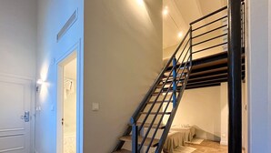 A staircase with a metal railing leading to a landing. - VTZ Orús Factory Hotel - Parking Muy Económico (Zaragoza)