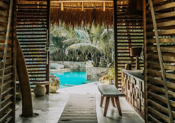 Een buitenzwembad, parasols bij het zwembad en ligstoelen