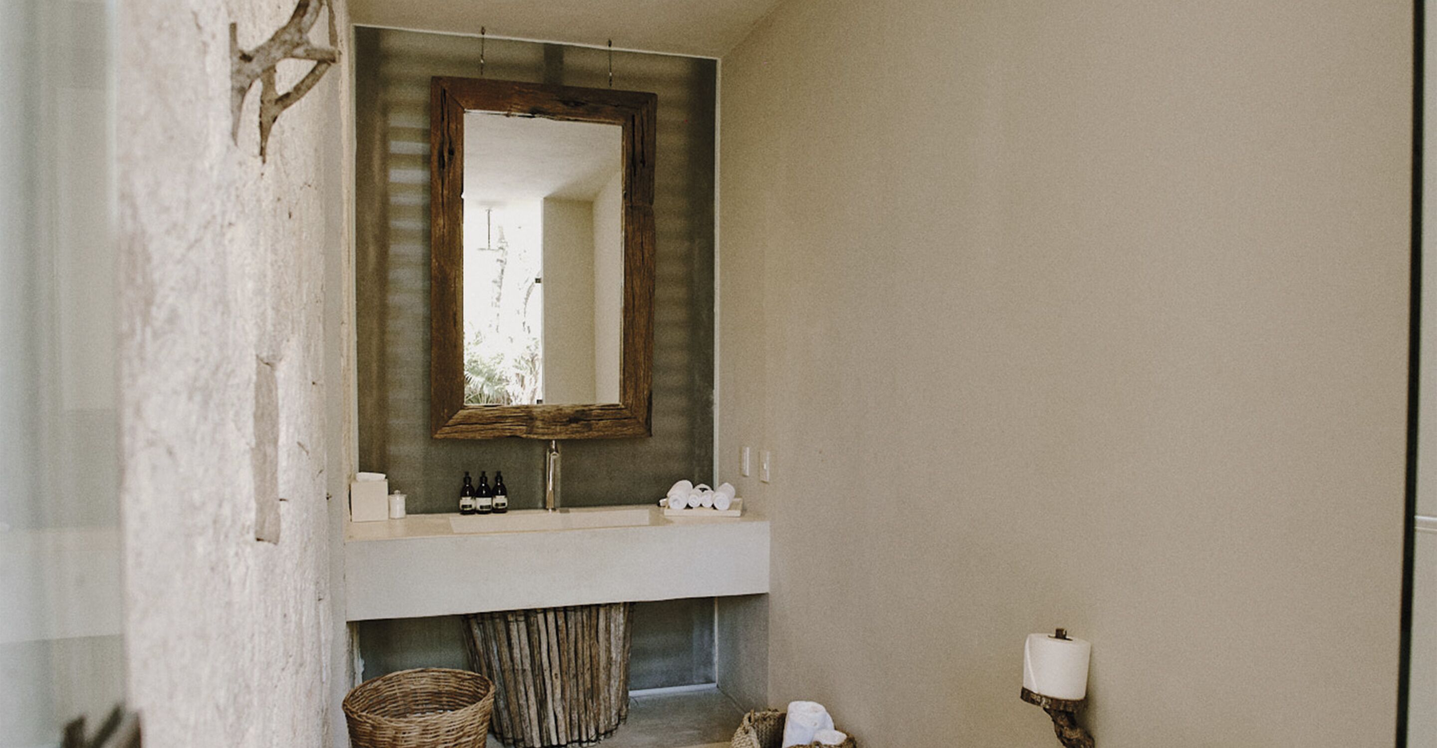 A bathroom with a large mirror, a sink, and a towel rack.