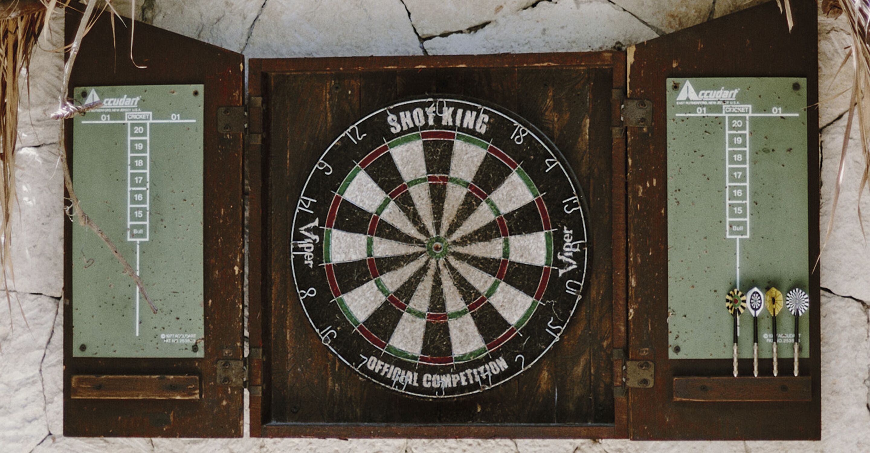 Dartbord aan een muur bevestigd, met een scorebord aan weerszijden.