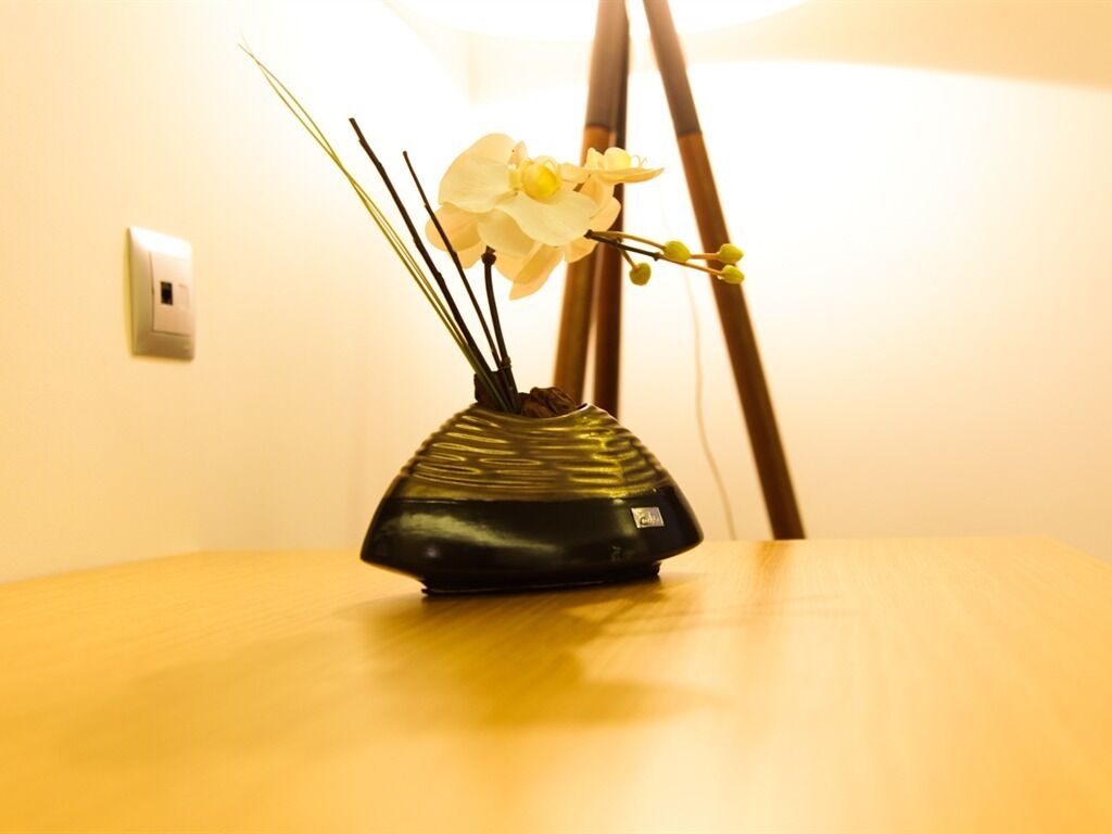 A black vase with a unique design on a wooden table.