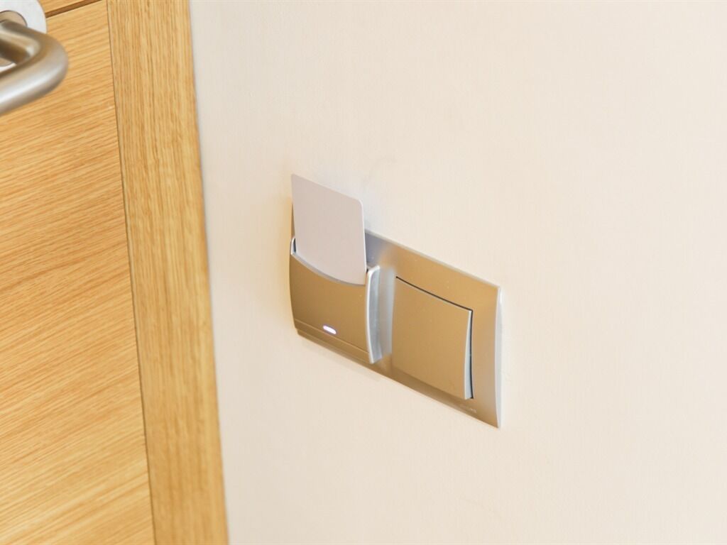 A wall-mounted light switch and a door handle.