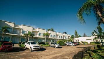 A row of modern buildings with a parking area in front.