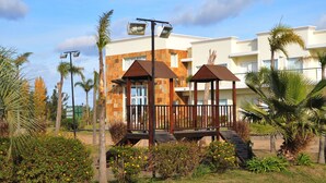 Ein Hotel mit modernem Design, mit einer Steinfassade, mehreren Balkonen und einem überdachten Außenbereich mit Holzgeländern.