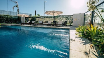 Alberca al aire libre y camastros