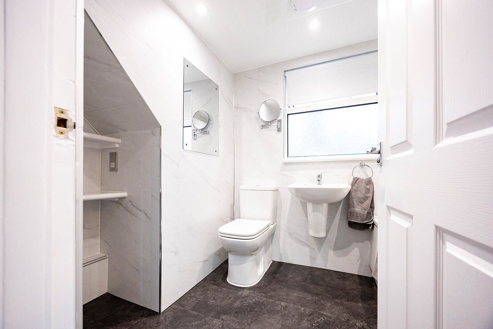 A modern bathroom with a toilet, sink, and mirror.