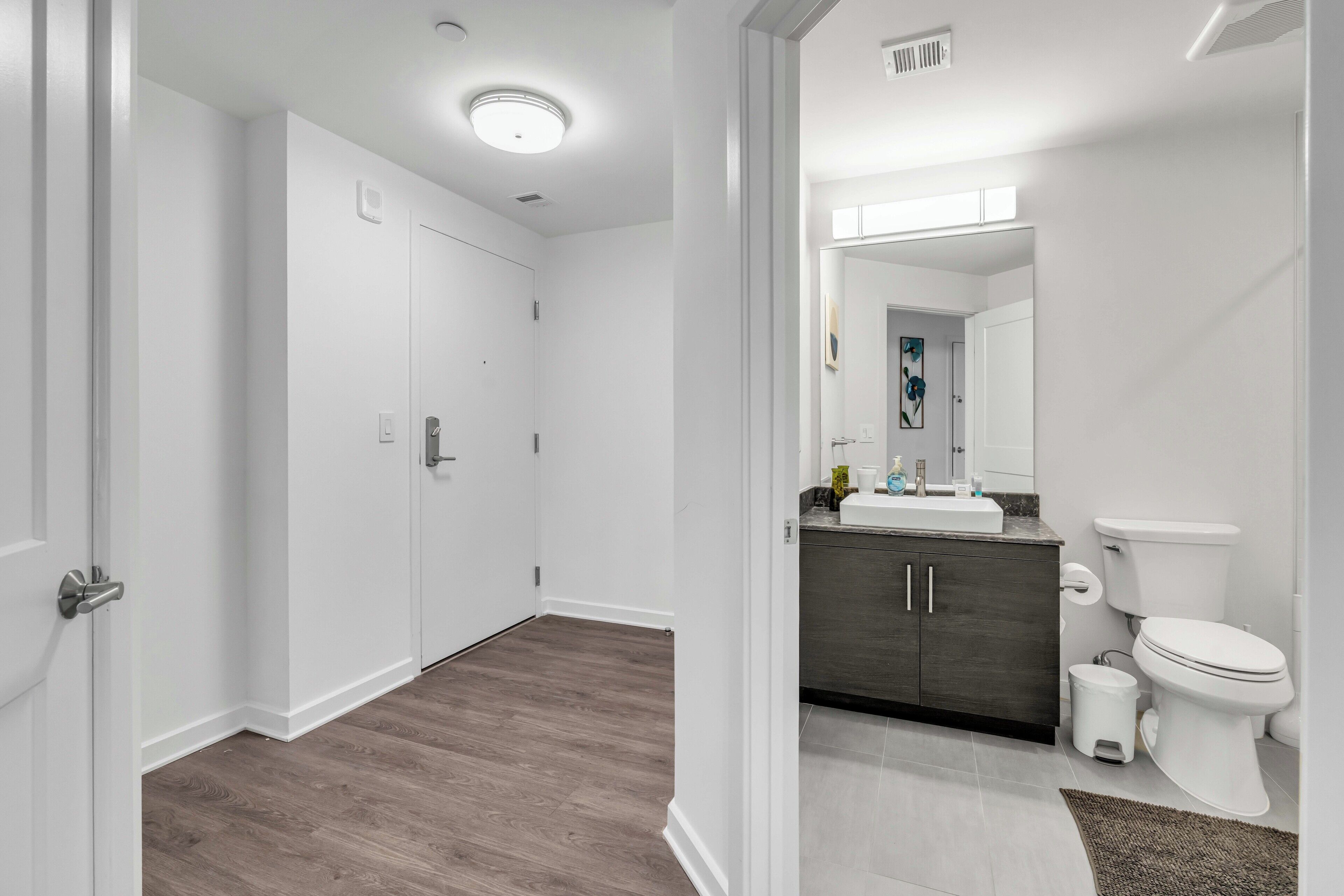 A modern bathroom with a toilet, sink, and cabinet.