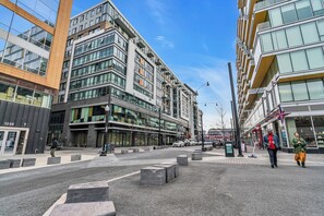 A modern urban street with contemporary buildings, a clear sky, and a pedestrian crossing. - Fully Furnished Apartments near Nationals Park (Washington)