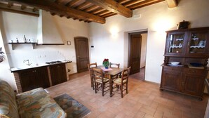 A cozy kitchen with a dining table, chairs, and a cabinet. - Holiday Home in Montone with Pool & Garden (Montone)
