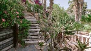 A stone staircase surrounded by lush greenery and various plants. - Villa in Cala Llonga near Beach & Ferry Port (Cala Llonga (santa Eulalia del Rio))
