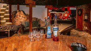 A billiards table, a pool table, and a wooden table with glasses and bottles. - Villa in Cala Llonga near Beach & Ferry Port (Cala Llonga (santa Eulalia del Rio))