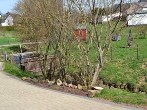 Stroll through a beautifully landscaped area, surrounded by lush plants and a serene pond.