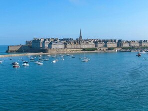 Un paysage urbain côtier avec un bâtiment historique remarquable et un ciel bleu dégagé.